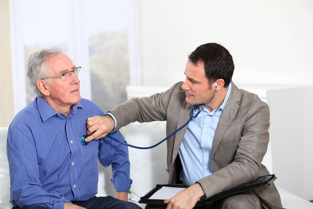Doctor examining elderly mans health