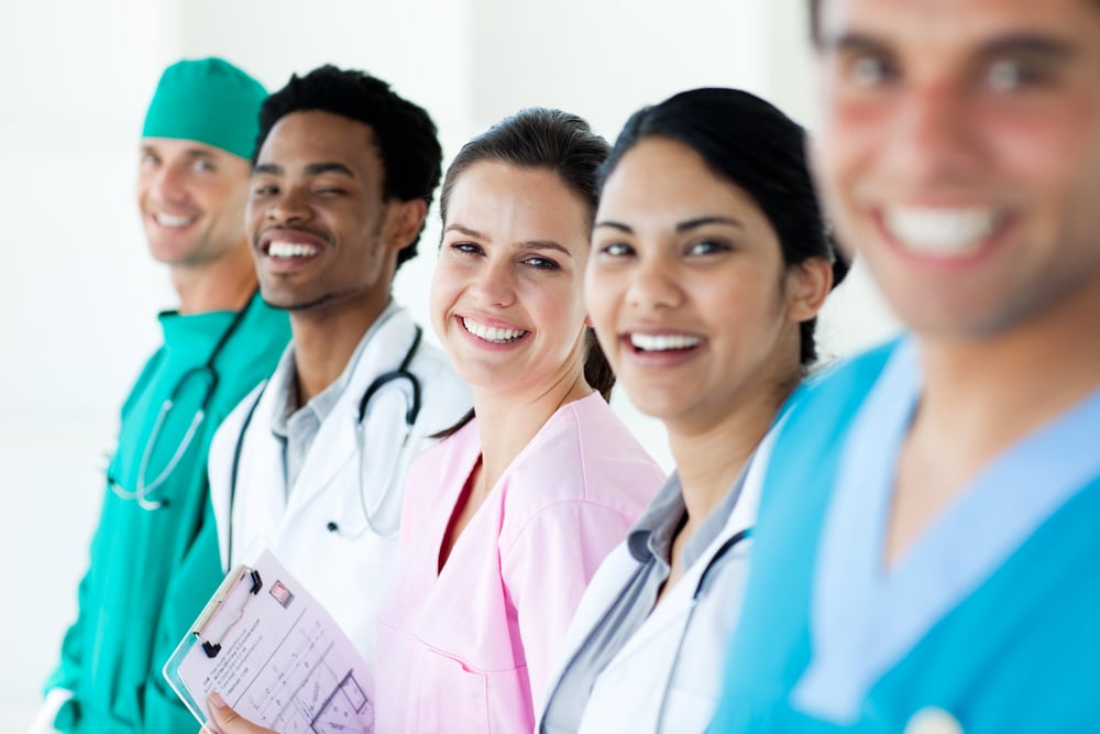 Smiling medical team in a line isolated on a white background Smiling medical team in a line isolated on a white background