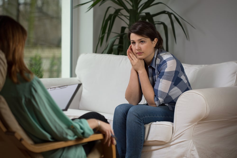 Young woman talking with psychologist about her problems-1